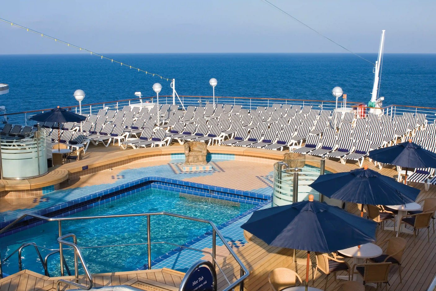 Pooldeck mit Schwimmbecken, Liegestühlen und Meerblick