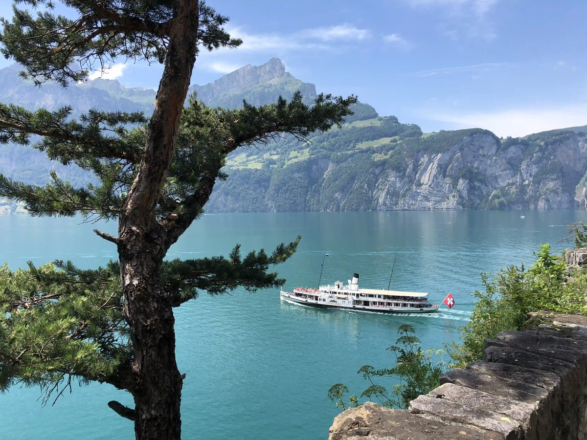 Bateau à passagers blanc naviguant sur leau turquoise du lac des Quatre Cantons devant des parois rocheuses