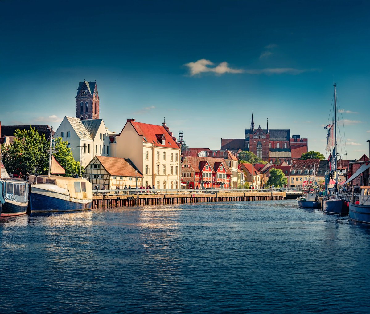 Blick auf den Hafen von Wismar mit historischen Häusern, Booten und Backsteinkirchen