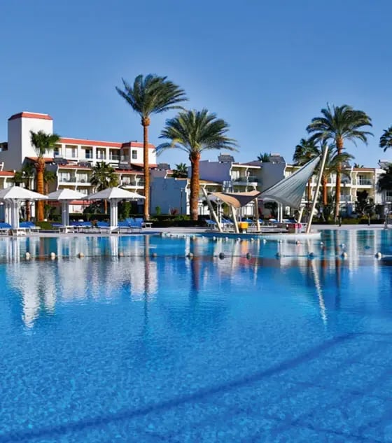 Grosszügige Poolanlage eines Resorts mit Palmen, Liegebereich und Hotelgebäuden am Roten Meer.