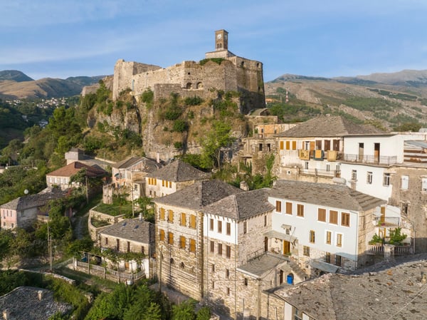 Steinerne Burg in Gjirokastër mit Garten, gepflastertem Weg und grüner Umgebung.