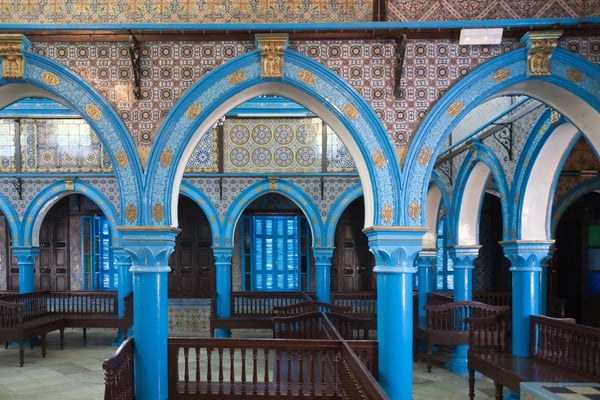 Innenraum mit kunstvollen blauen Bögen und traditionellen Fliesen in der El-Ghriba-Synagoge.