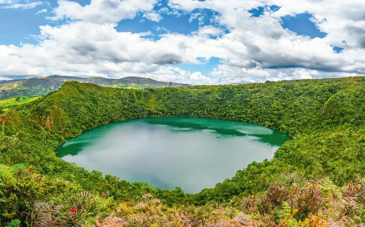 Smaragdgrüne Lagune von Guatavita, umgeben von dichter Vegetation.