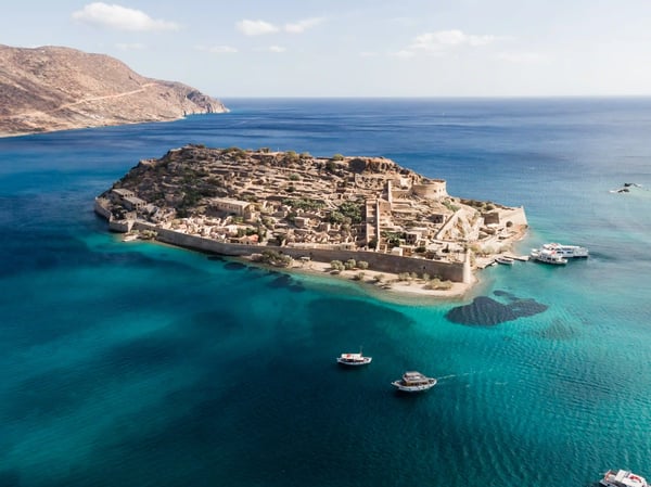 Luftaufnahme der Insel Spinalonga mit historischer Festung im türkisblauen Meer