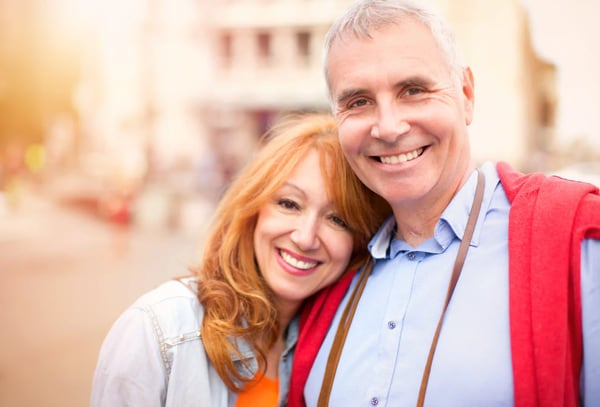 Glückliches Paar lächelt in die Kamera bei einem Stadtbummel
