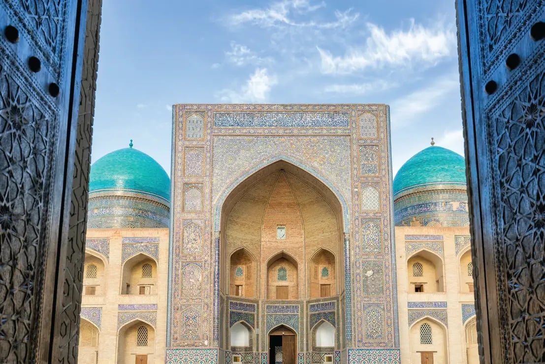 Eingang der Kalyan-Moschee in Buchara mit türkisfarbener Kuppel und kunstvollen Mosaiken.