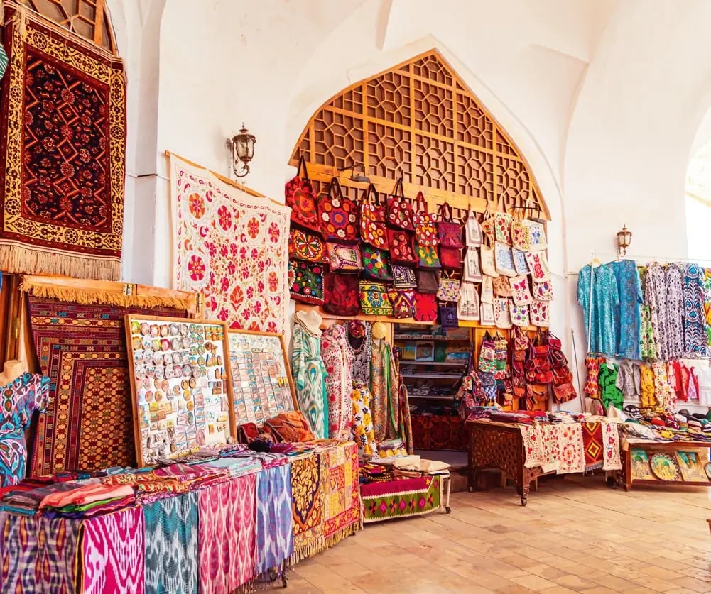 Traditioneller Basar mit farbenfrohen Teppichen, bestickten Textilien und regionaler Handwerkskunst.
