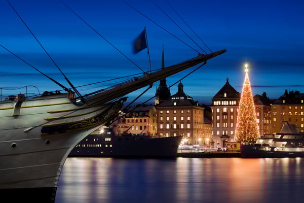 Stockholm bei Nacht mit beleuchtetem Hafen, Schiff und grossem Weihnachtsbaum.