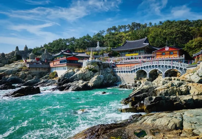 Haedong-Yonggungsa-Tempel auf felsiger Küste mit Blick auf das Meer.