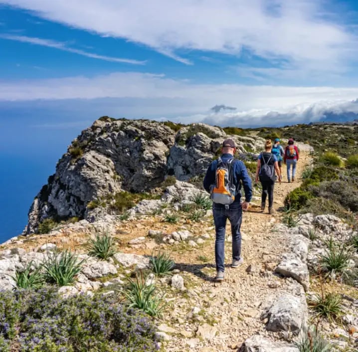Wandergruppe auf einem Küstenweg mit Blick auf das Mittelmeer auf Mallorca.