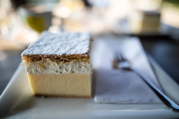 Stück Bleder Cremeschnitte mit Vanillecreme, Sahneschicht und Blätterteig auf einem Teller
