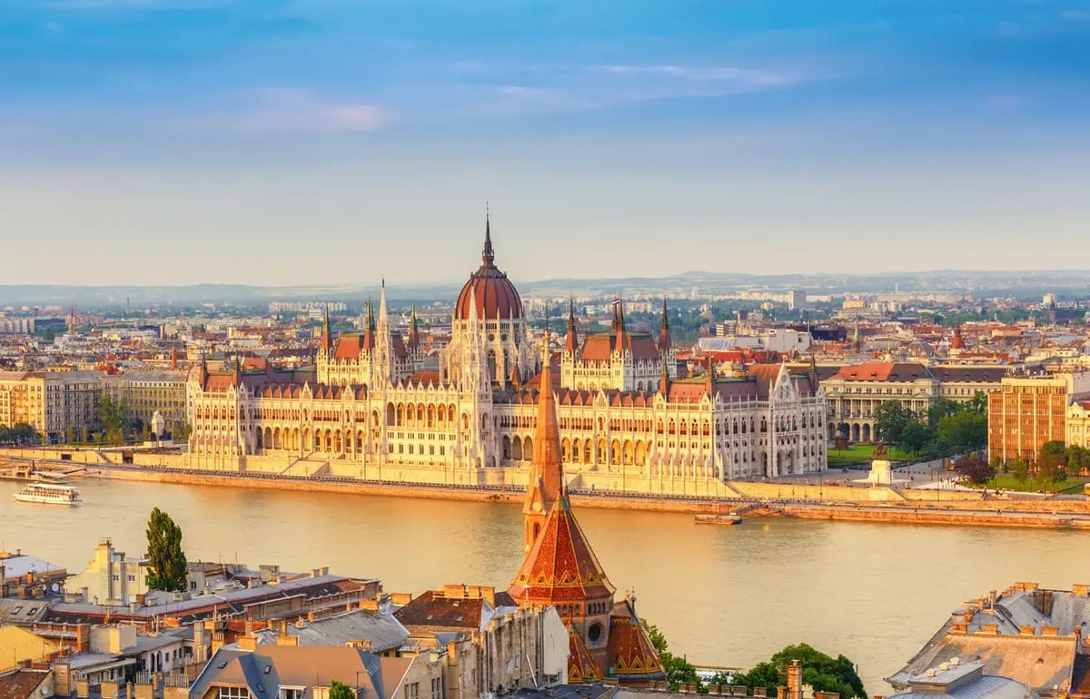 Vue sur le majestueux Parlement de Budapest depuis les rives du Danube, baigné par la lumière chaude du soir