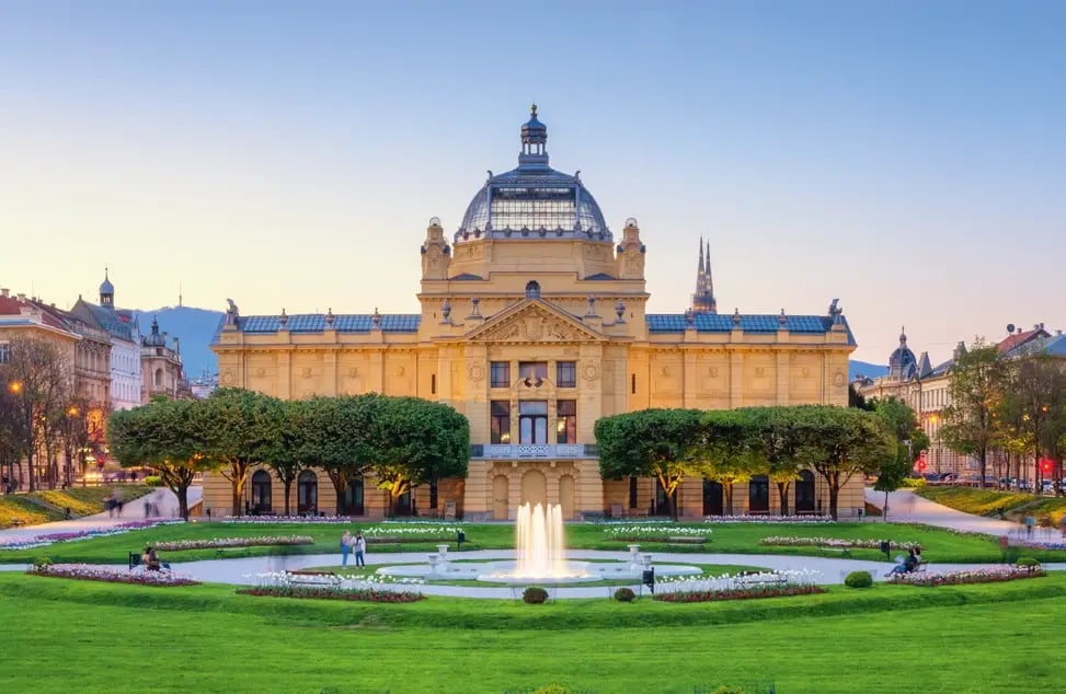 Pavillon des Arts à Zagreb avec une fontaine et un parc soigneusement aménagé au premier plan