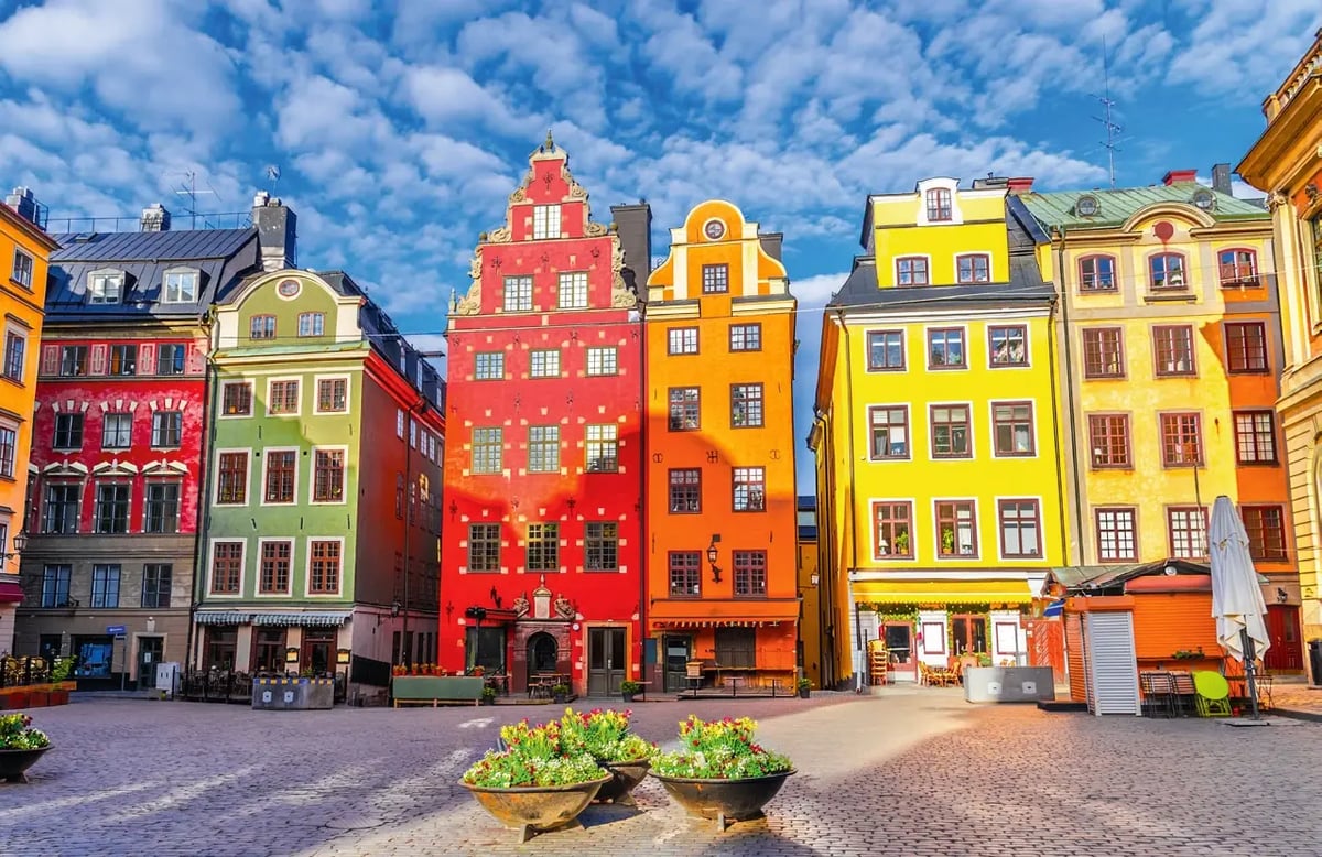 Bunte historische Häuser am Stortorget in der Altstadt von Stockholm unter blauem Himmel.