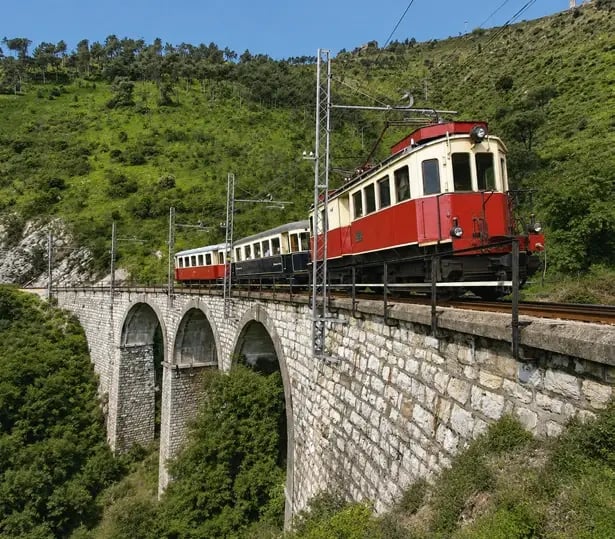 Train historique de la ligne Casella sur un viaduc au cœur des collines verdoyantes près de Gênes