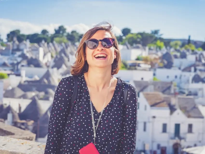 Lachende Reisende vor den berühmten Trulli-Häusern von Alberobello.