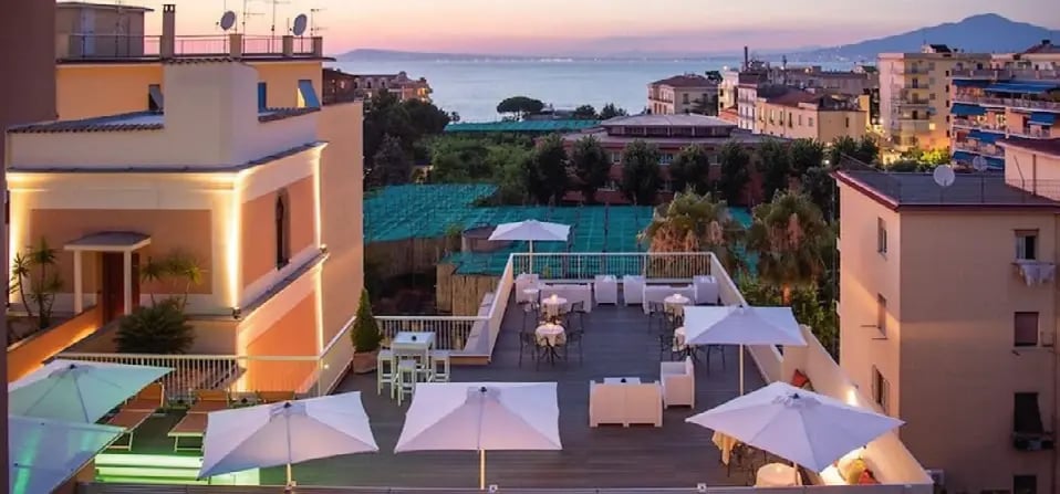 Dachterrasse des Hotels Michelangelo in Sorrent mit Blick auf den Golf von Neapel bei Abendstimmung.