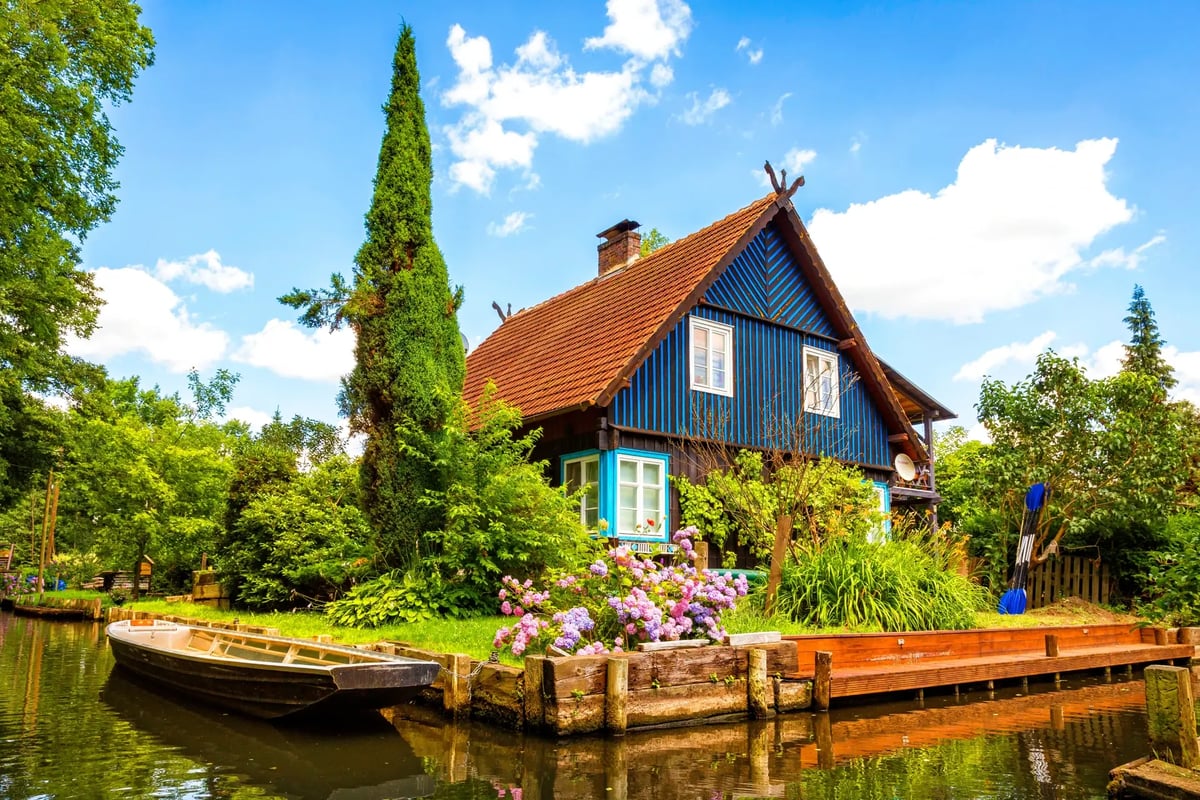 Traditionelles Holzhaus mit Bootsanleger an einem idyllischen Kanal im Spreewald.