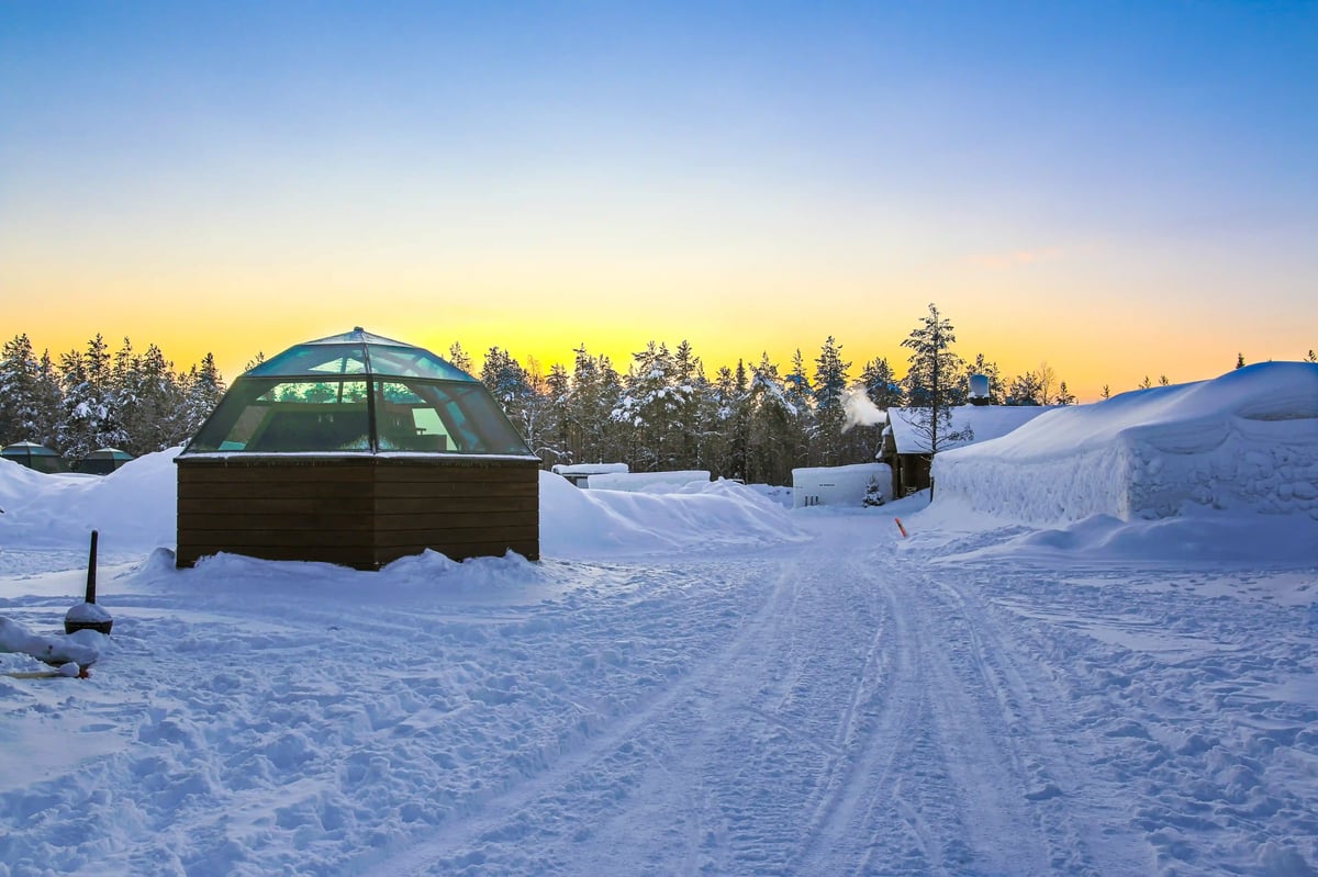 Das Arctic Snow Hotel bei Rovaniemi in Finnisch Lappland mit Glas Igloos inmitten der verschneiten Winterlandschaft – ideal zur Beobachtung der Nordlichter.