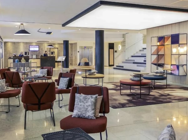 Moderne Hotellobby in Blois mit Sitzbereichen, Rezeption und stilvoller Einrichtung.