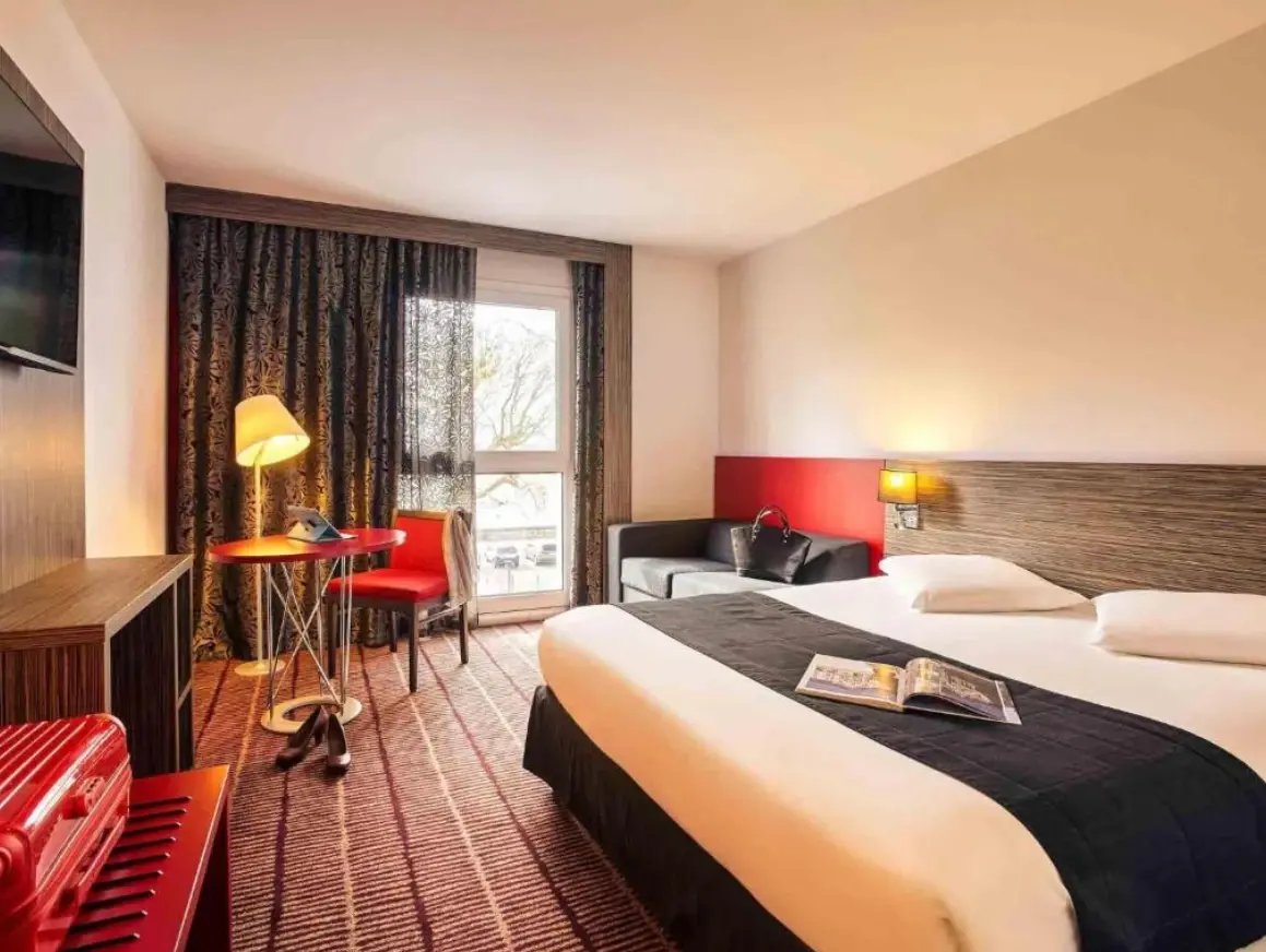 Komfortables Hotelzimmer in Blois mit Doppelbett, Schreibtisch und gemütlicher Ausstattung.