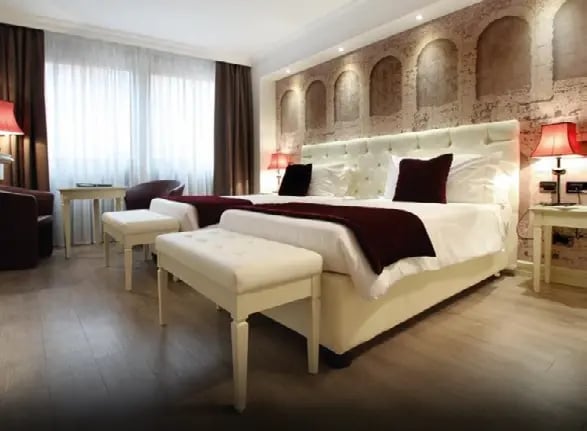 Modernes Hotelzimmer mit Doppelbett, Sitzbereich und eleganter Beleuchtung.