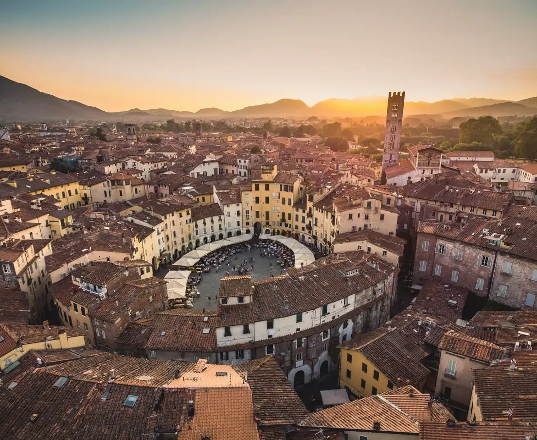 Panoramablick über die Altstadt von Lucca mit der Piazza dell’Anfiteatro bei Sonnenuntergang.