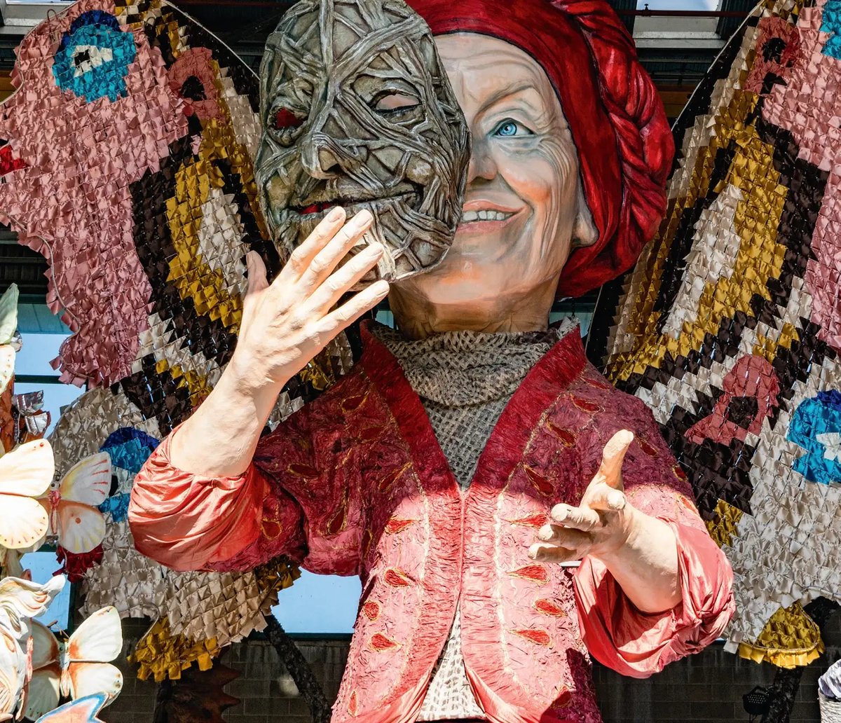 Grosse Karnevalsfigur mit halb geöffneter Maske auf einem kunstvoll gestalteten Festwagen in Viareggio.
