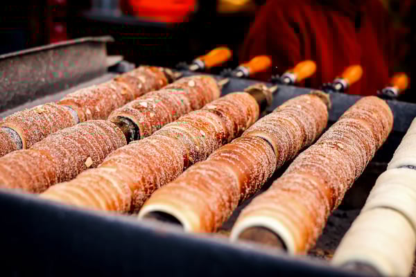 Frisch gebackene Baumstriezel mit Zucker auf einem Grill aufgereiht