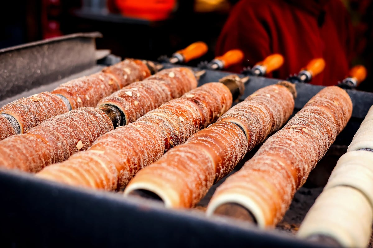 Frisch gebackene Baumstriezel mit Zucker auf einem Grill aufgereiht