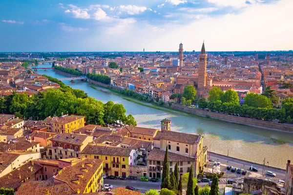 Panoramablick auf Verona mit Fluss Etsch historischen Gebäuden und Türmen unter blauem Himmel