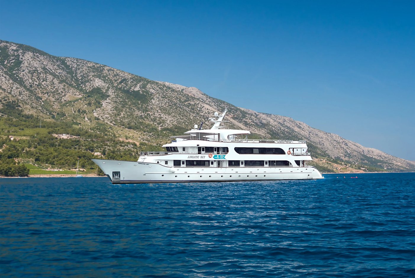 Le MS Adriatic Sky navigue sur une mer calme le long de la cote adriatique sous un ciel degage.