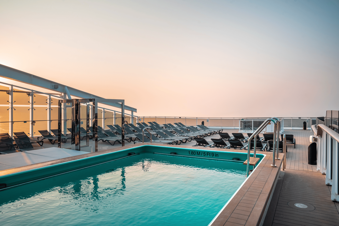 Pool auf dem Sonnendeck mit Liegen und Blick auf das offene Meer