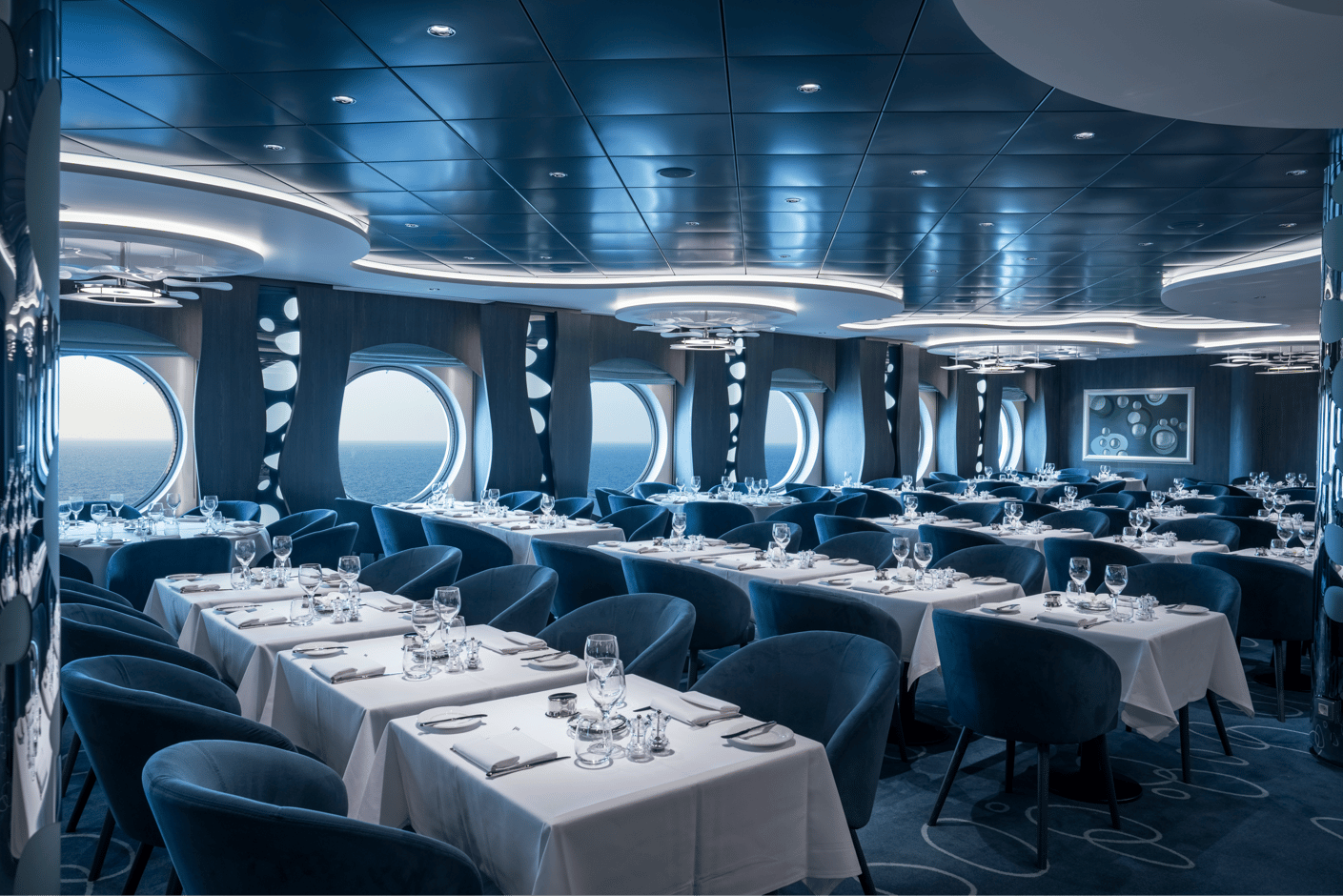 Elegantes Restaurant mit gedeckten Tischen und Panoramafenstern zum Meer