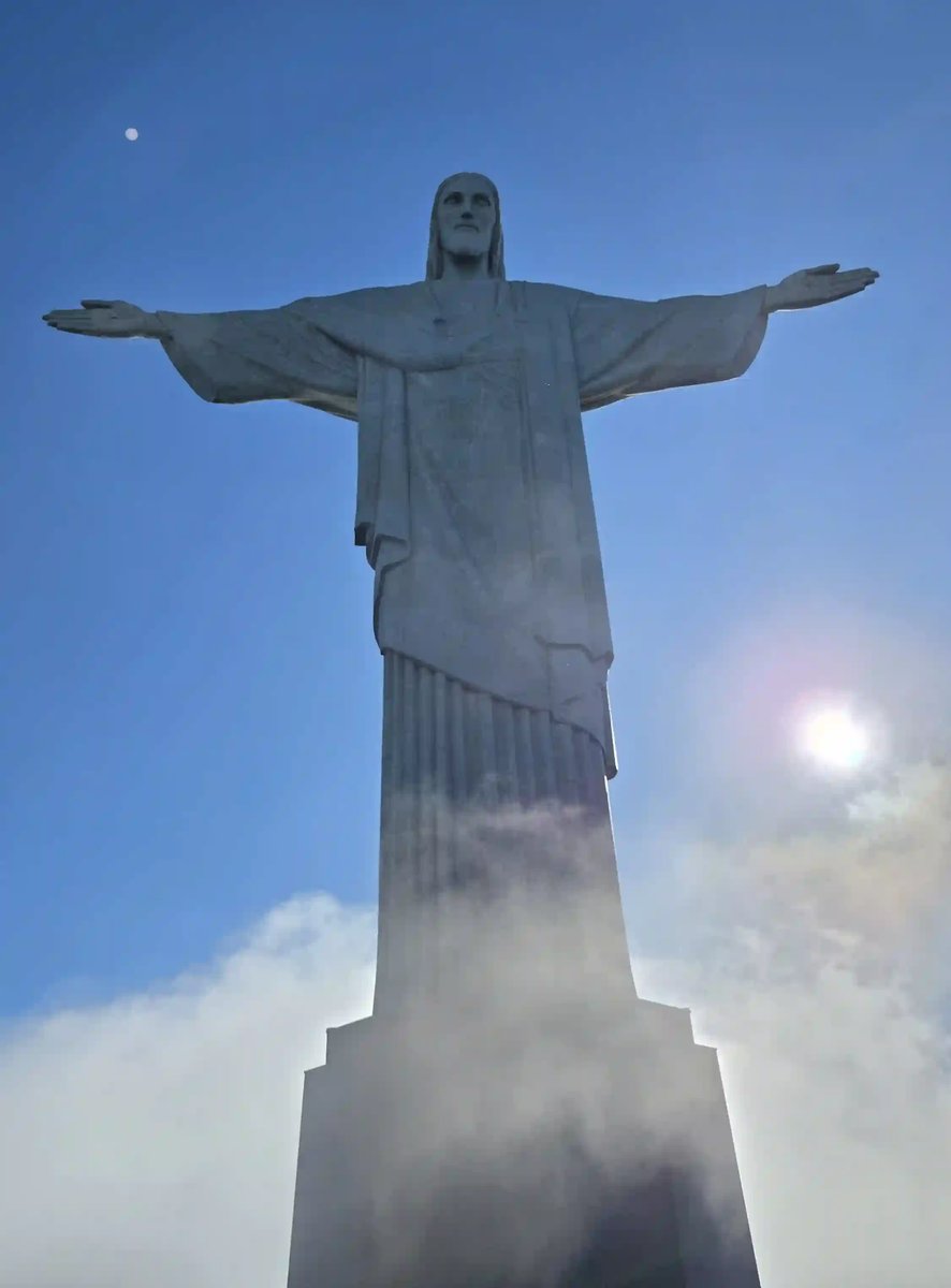 Christusstatue Cristo Redentor vor blauem Himmel und aufziehenden Wolken