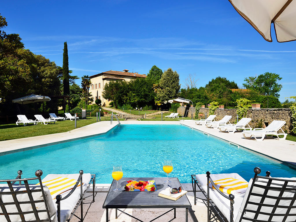 Pool der Villa Sabolini mit Liegen und Blick auf die toskanische Landschaft.