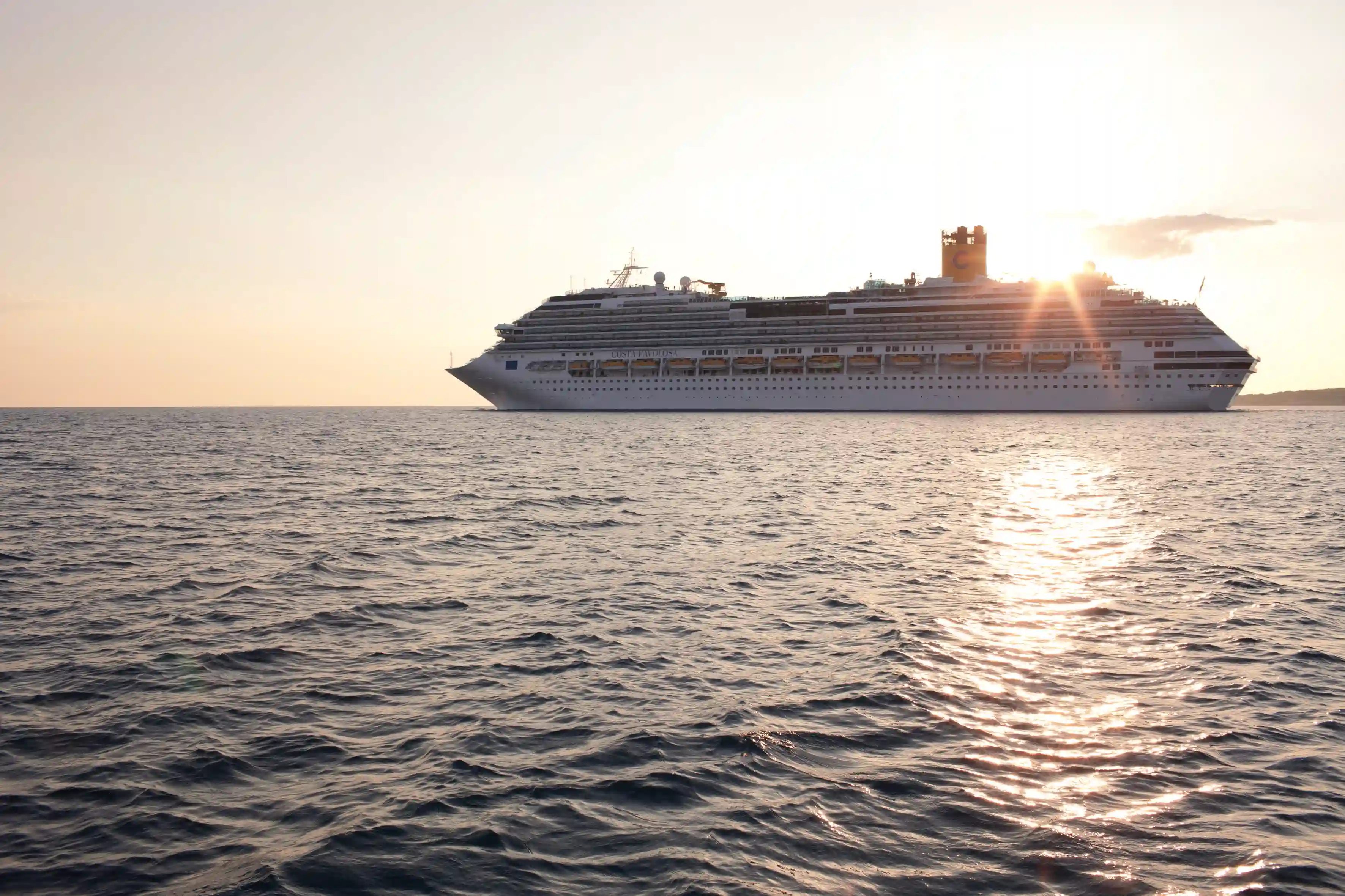 Kreuzfahrtschiff auf offenem Meer bei Sonnenuntergang