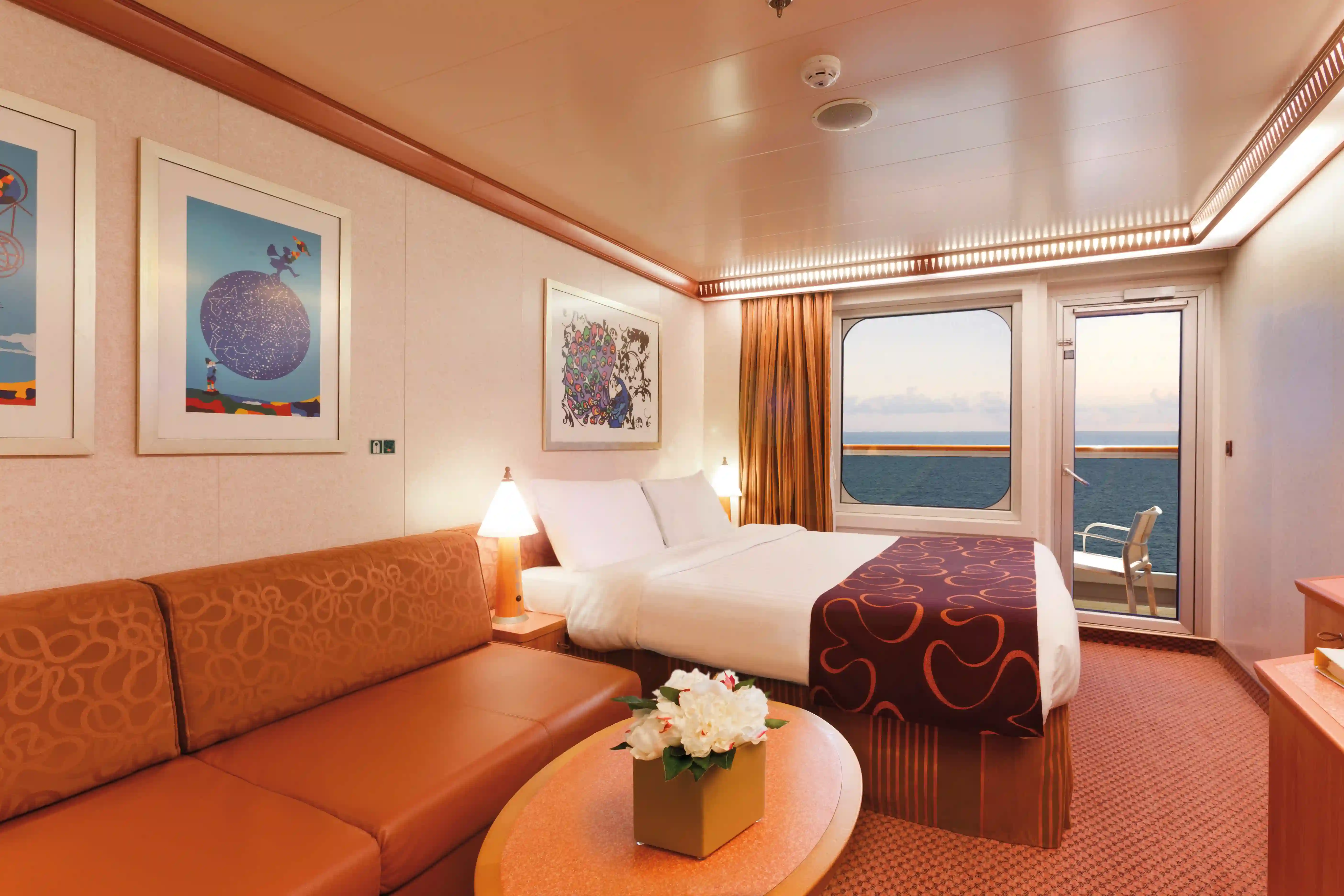 Balkonkabine auf Kreuzfahrtschiff mit Doppelbett, Sofa und Meerblick durch Glastür