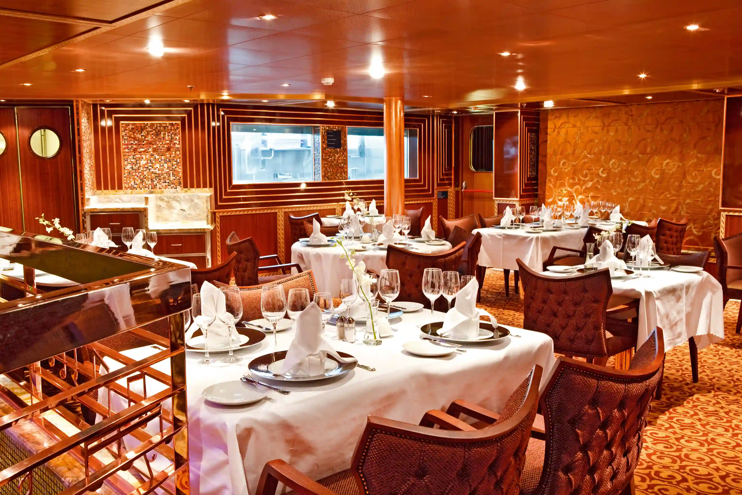 Elegantes Restaurant an Bord mit gedeckten Tischen und warmem Licht