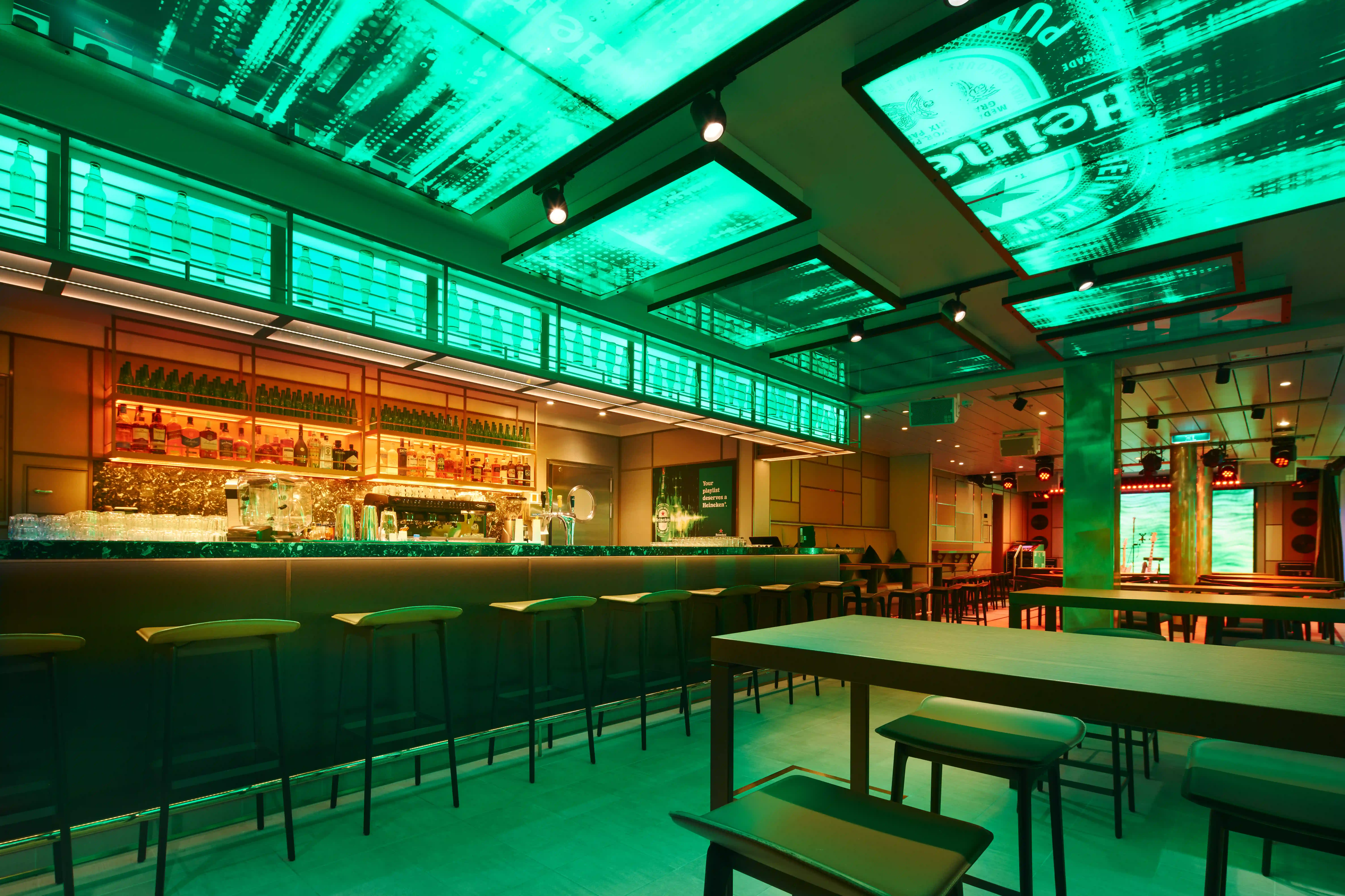 Bar moderne sur navire de croisière avec comptoir, tabourets et éclairage vert