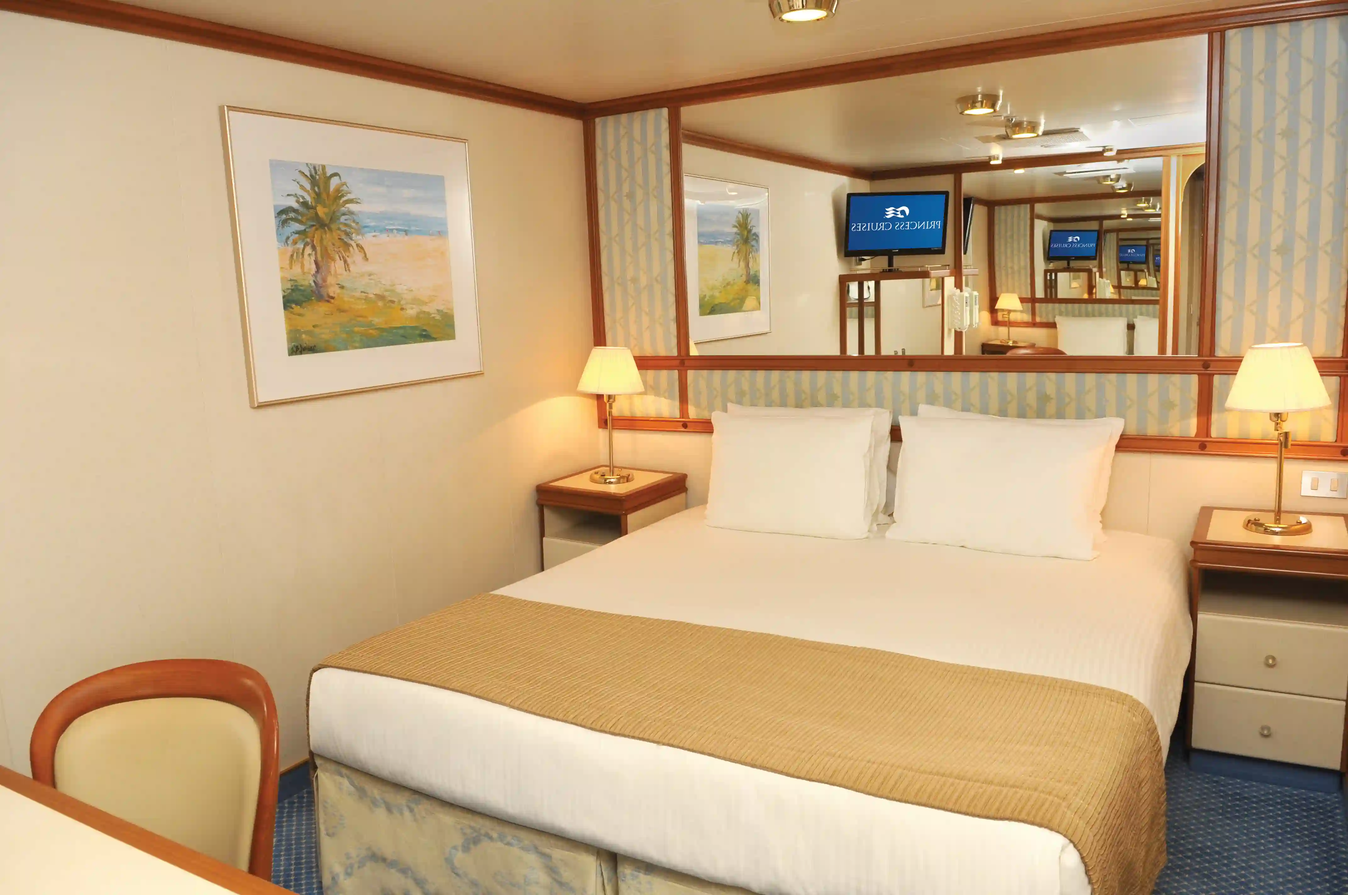 Innenkabine mit Doppelbett, Nachttischen, Spiegelwand und warmer Beleuchtung