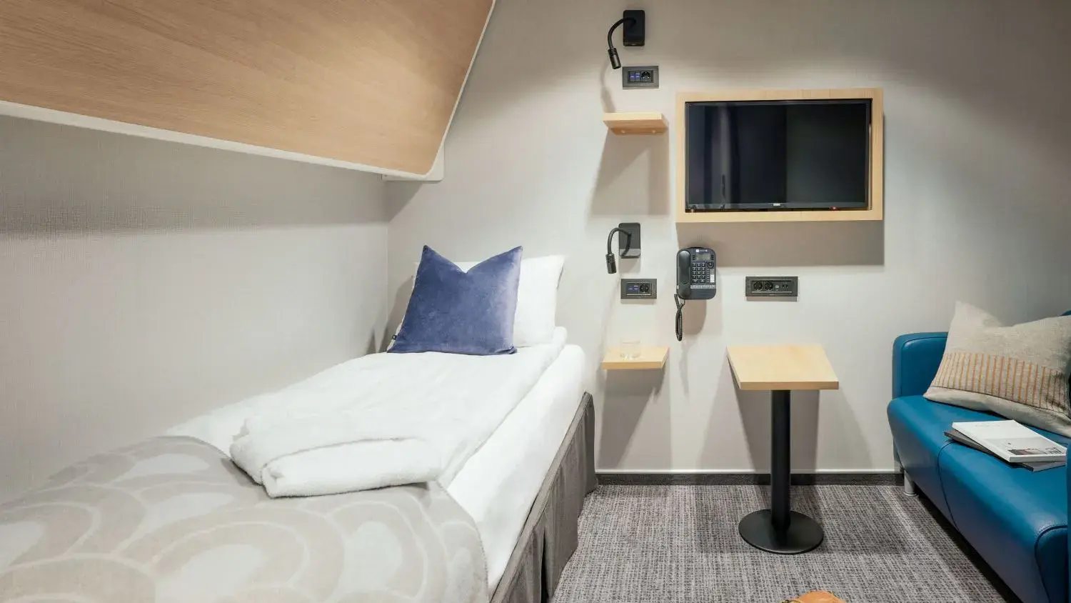 Innenkabine mit Einzelbett, Fernseher und kleinem Tisch