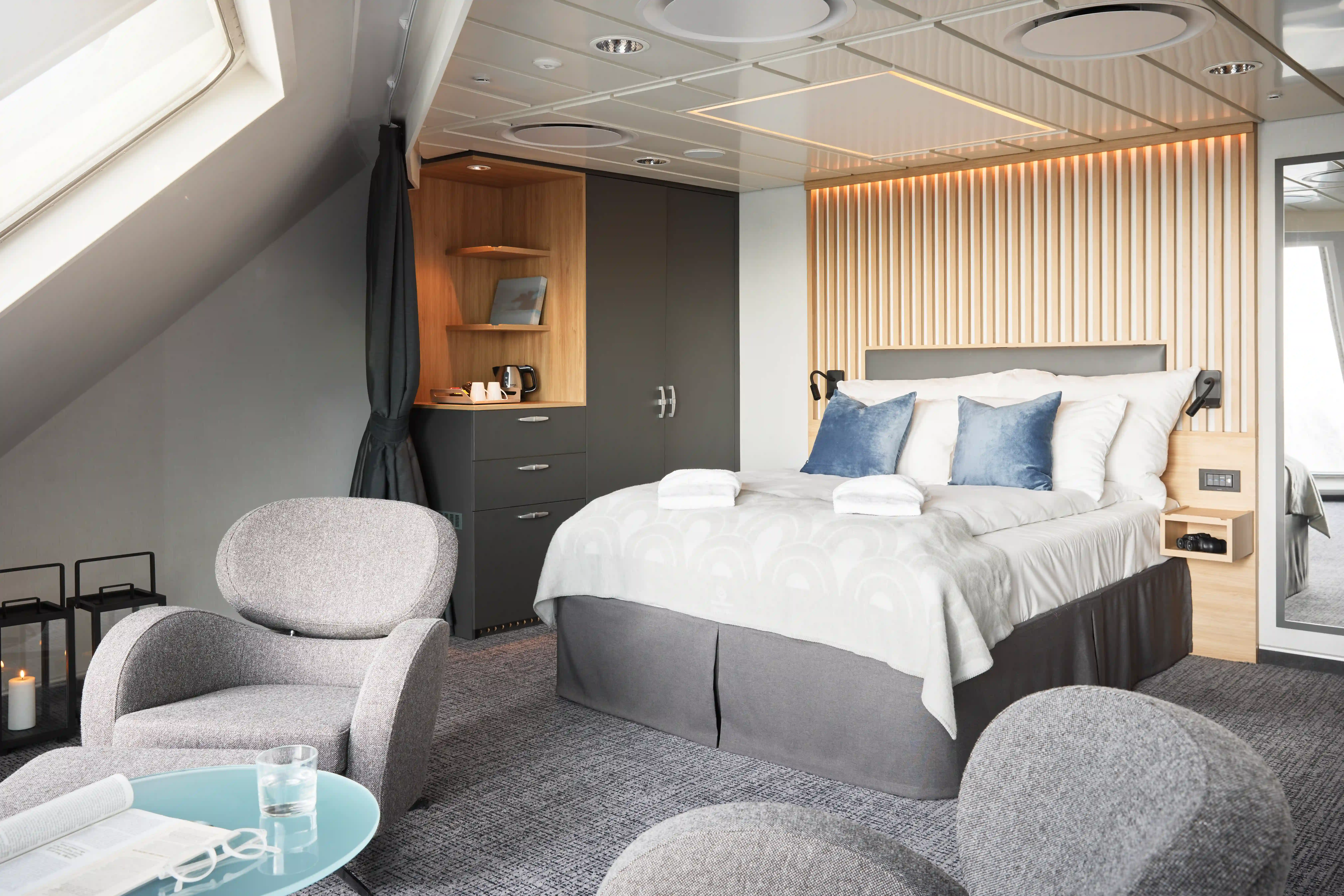 Suite mit Doppelbett, Sitzmöbeln und großer Fensterfront