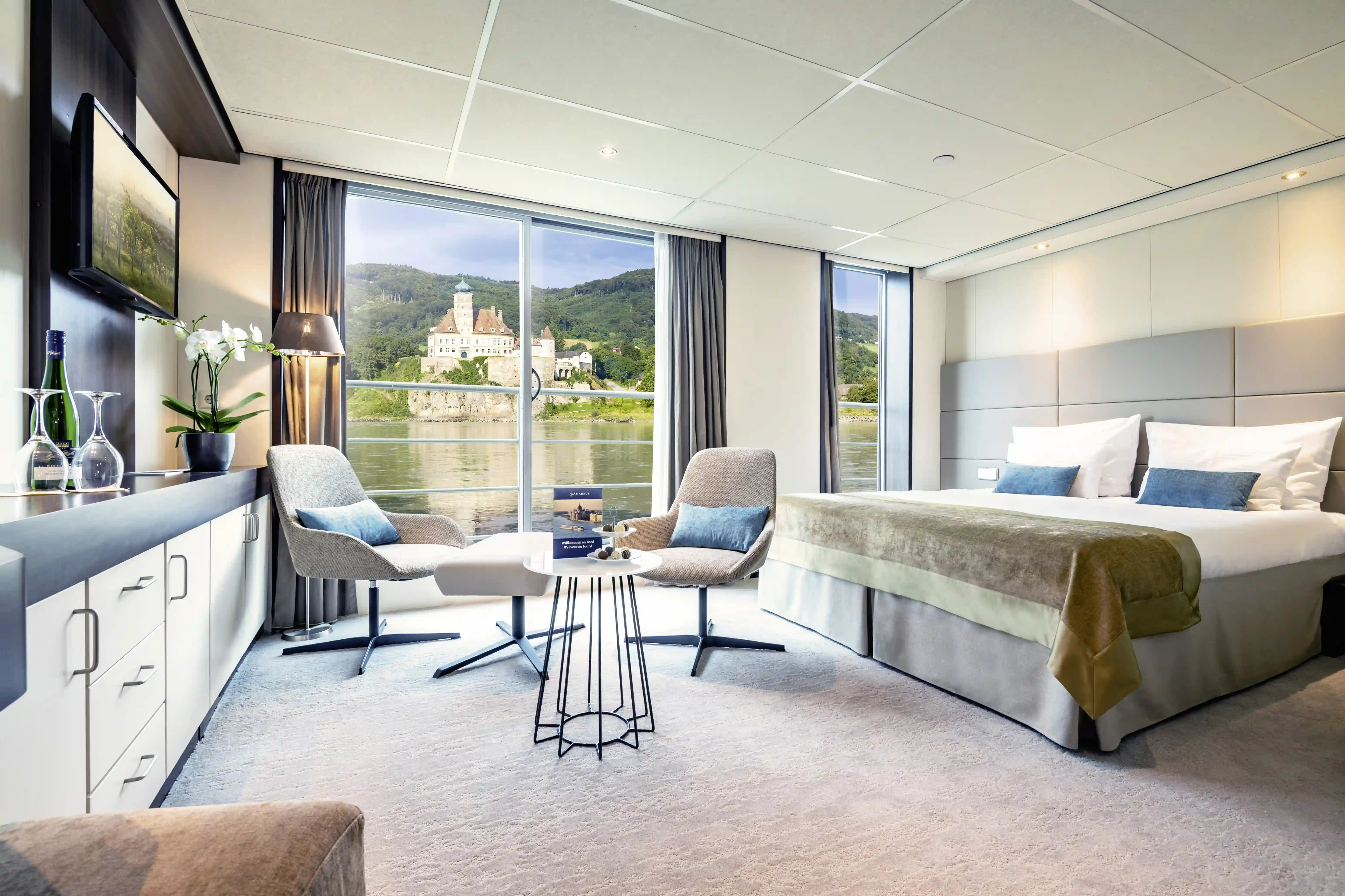 Suite mit Doppelbett, Sitzbereich und Panoramafenster zum Fluss