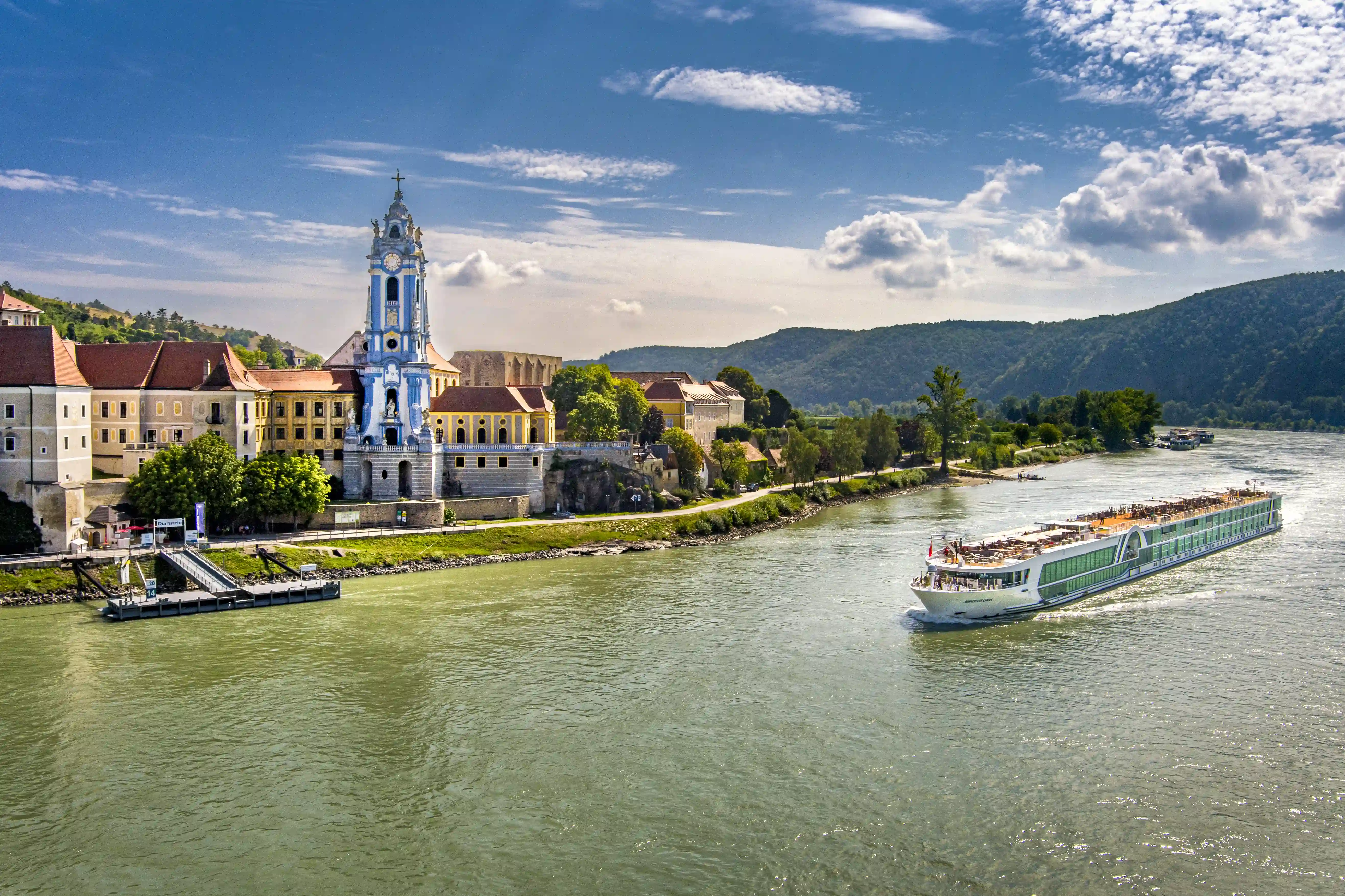 Flusskreuzfahrtschiff auf dem Rhein vor historischer Stadt