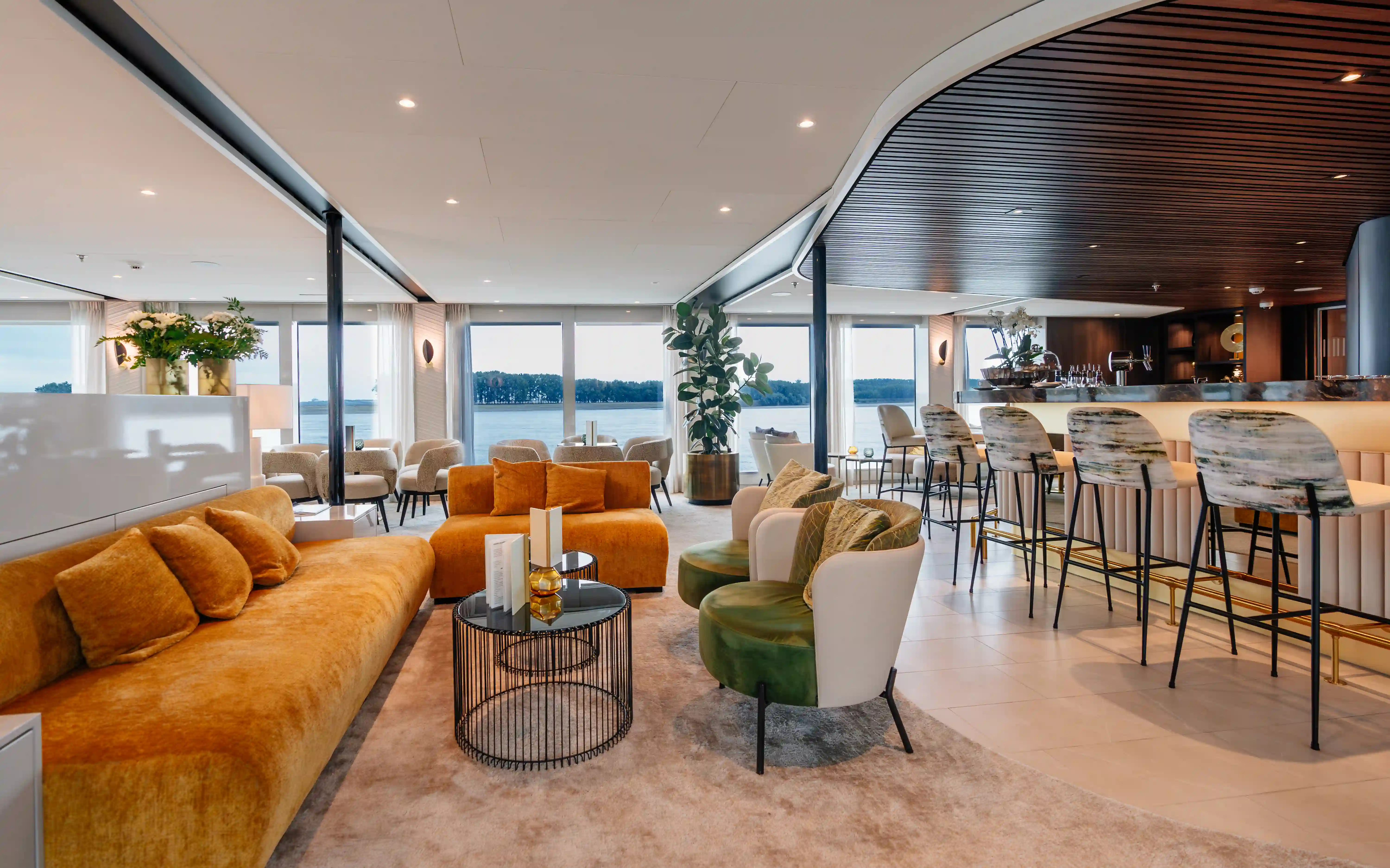 Panorama-Lounge mit Sesseln und grossen Fenstern
