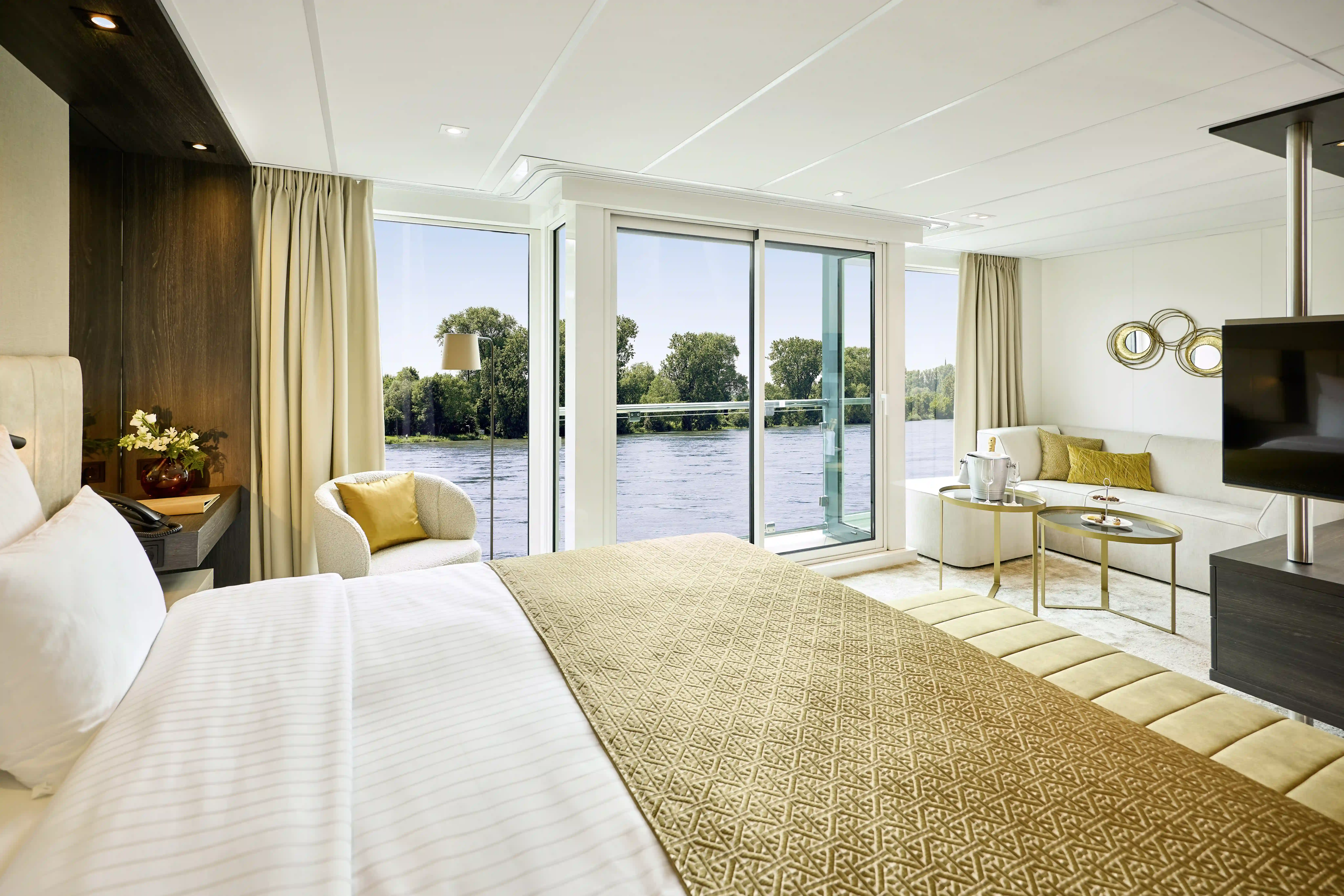 Suite eines Flusskreuzfahrtschiffs mit Balkon und Flussblick