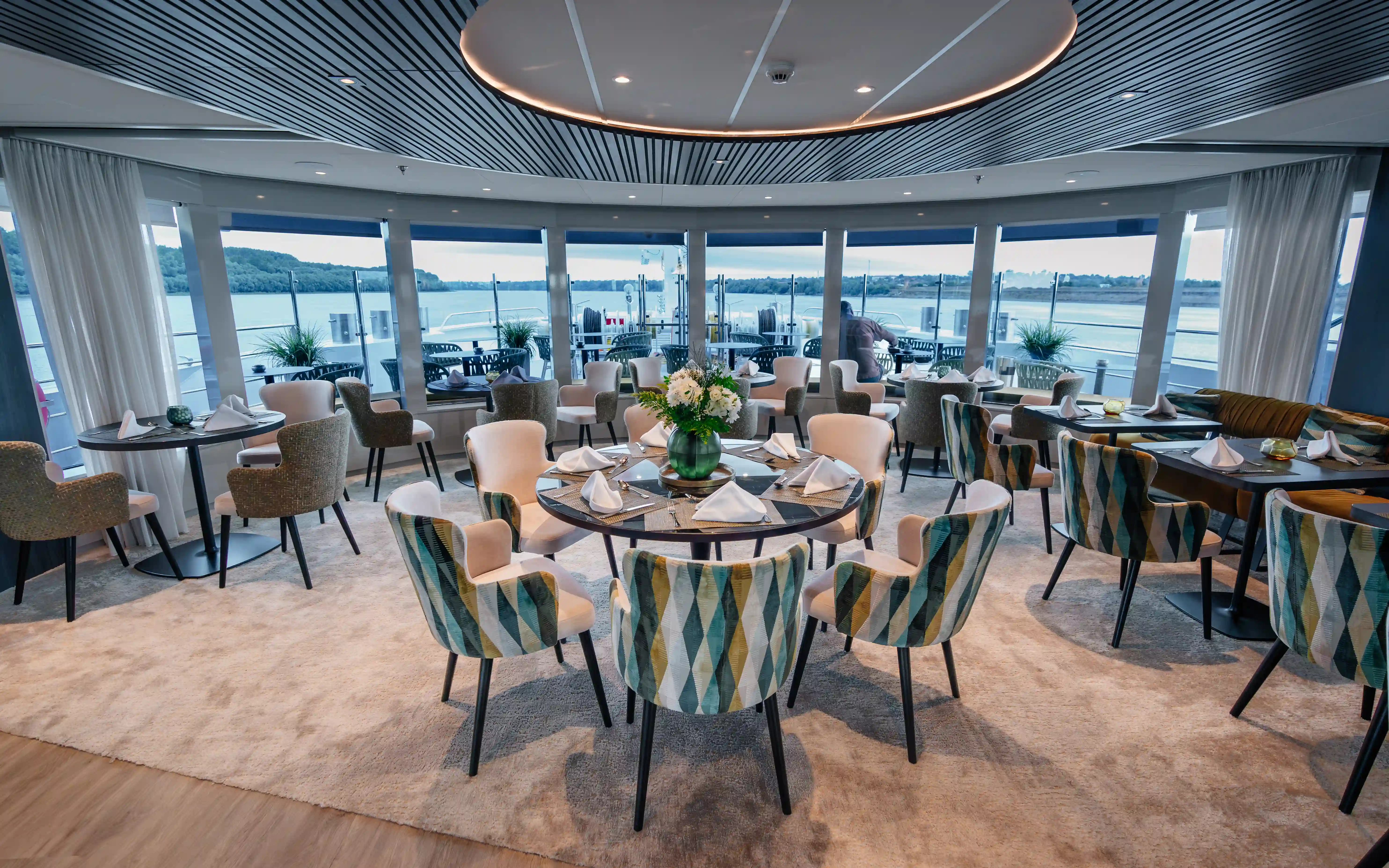 Panorama-Restaurant eines Flusskreuzfahrtschiffs mit gedeckten Tischen
