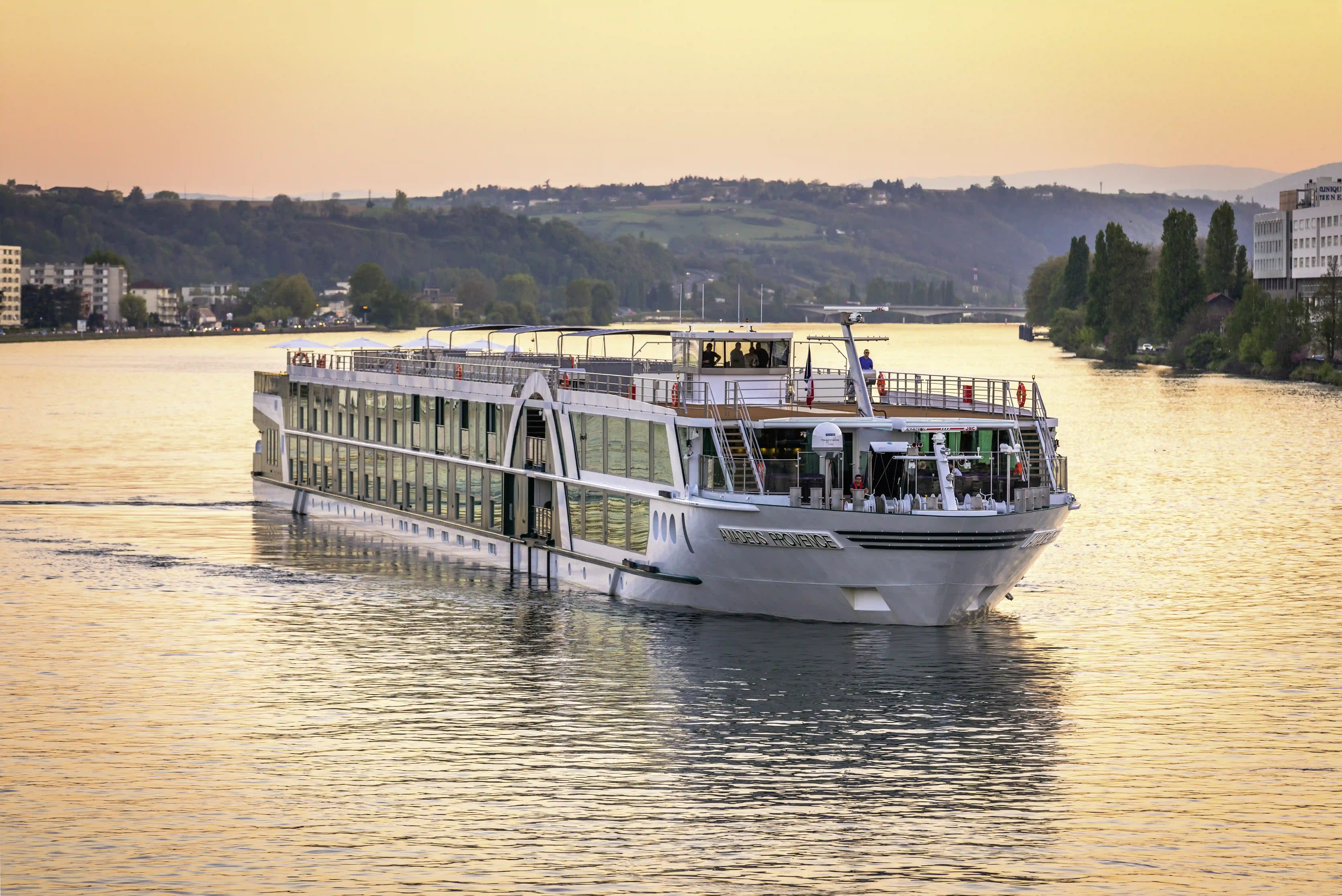 Flusskreuzfahrtschiff MS AMADEUS Provence bei Sonnenuntergang auf ruhigem Gewässer