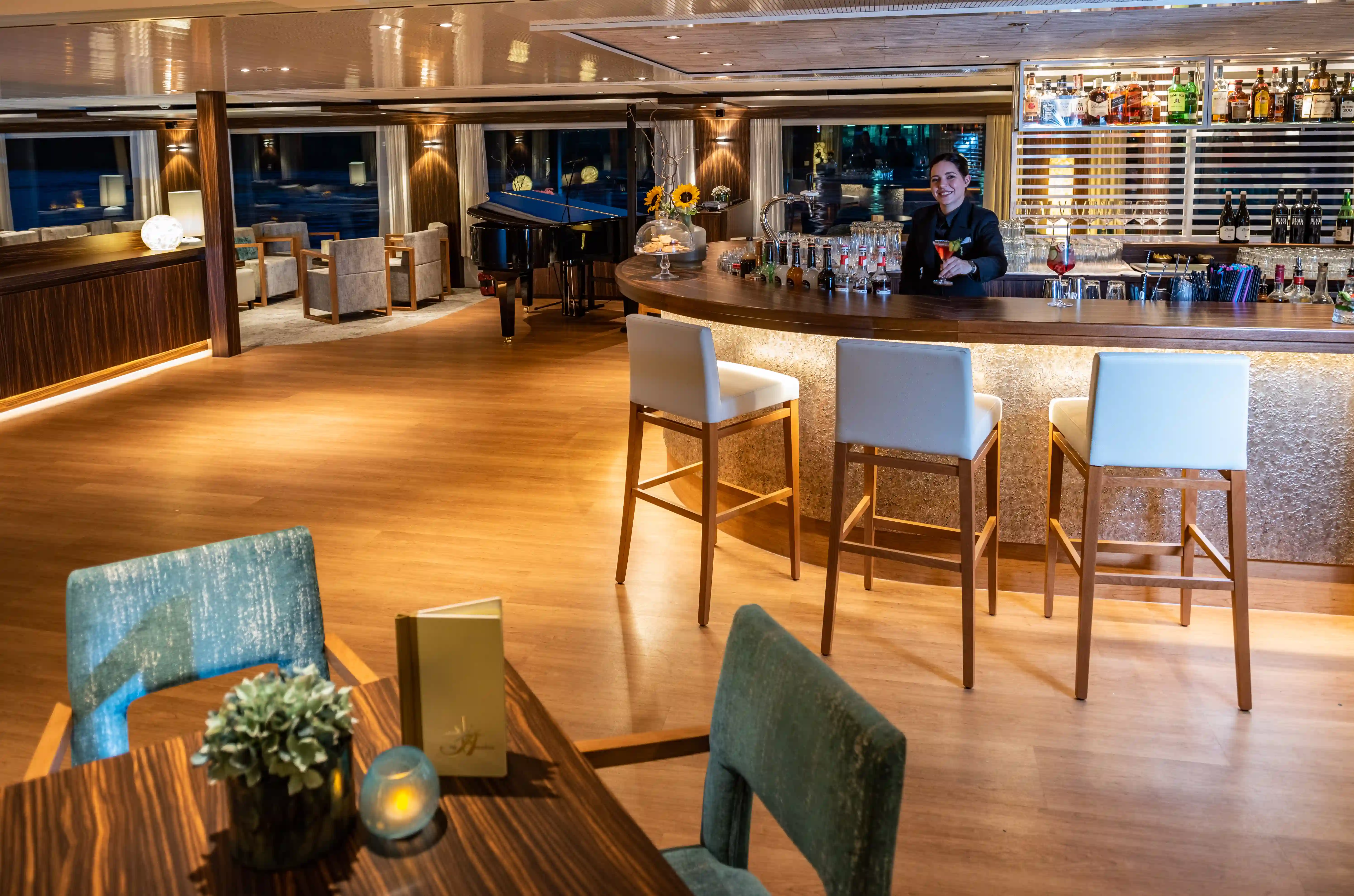 Stilvolle Panorama-Bar an Bord des AMADEUS Star mit eleganter Theke, gemütlichen Sitzgelegenheiten und entspannter Abendatmosphäre